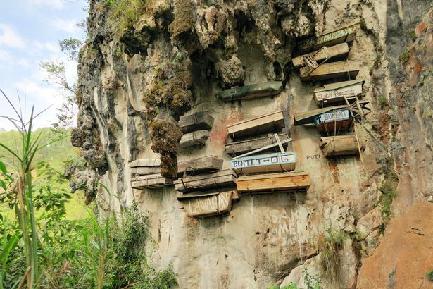Funeral strippers and cigarette in lips: Unusual death customs observed around the world Hundreds of wooden coffins dangle from cliffs and caves